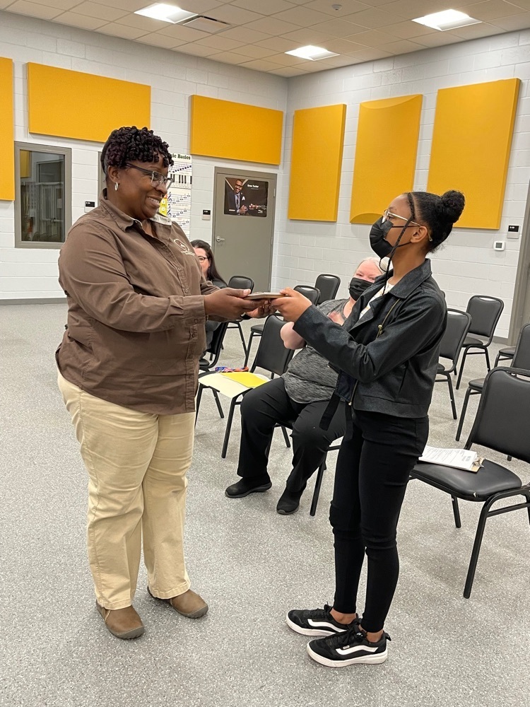 this is a picture of school board president Linda Chaney reading the second place art contest winner award to Brielle Tanner